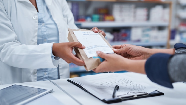 Close up of pharmacist handing over a prescription